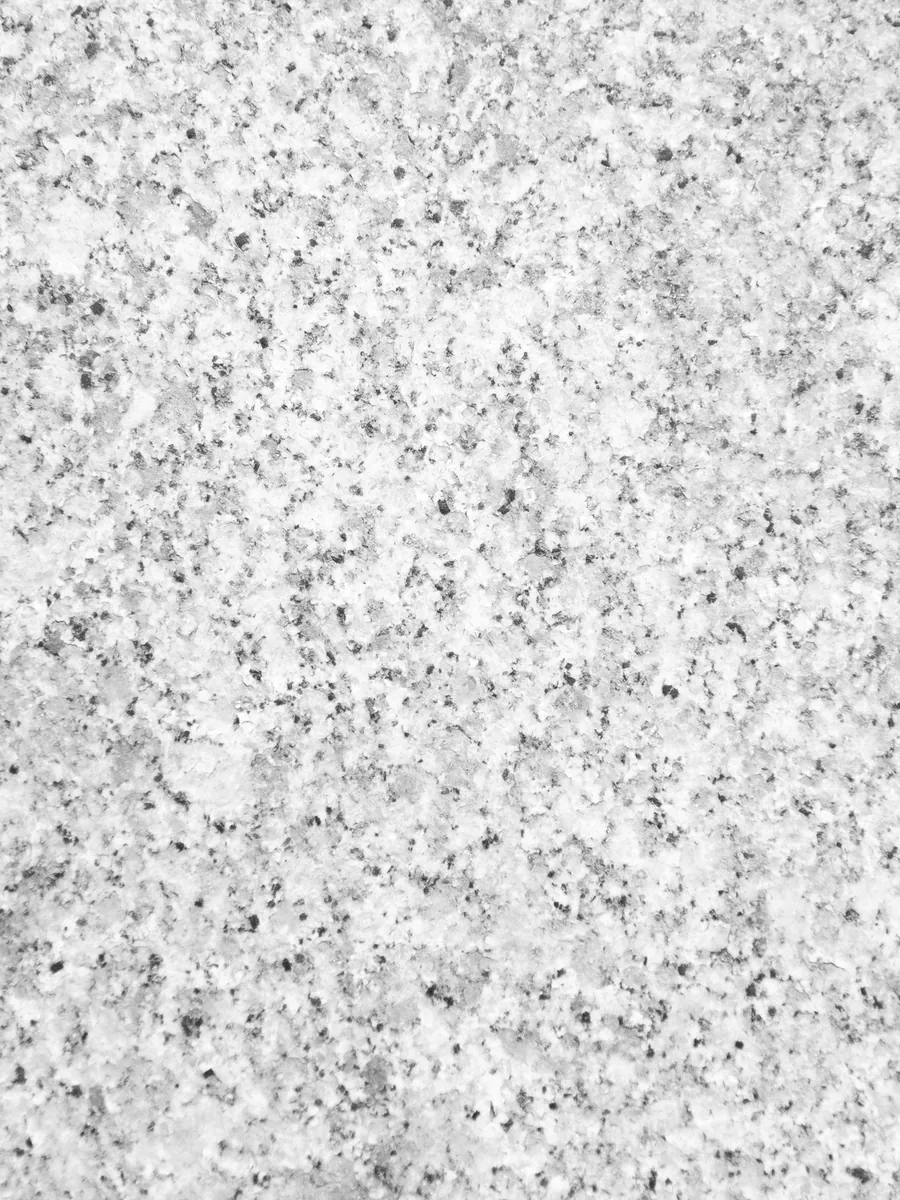 Chapa de granito branco Itaúnas em close, com grão fino cinza e preto